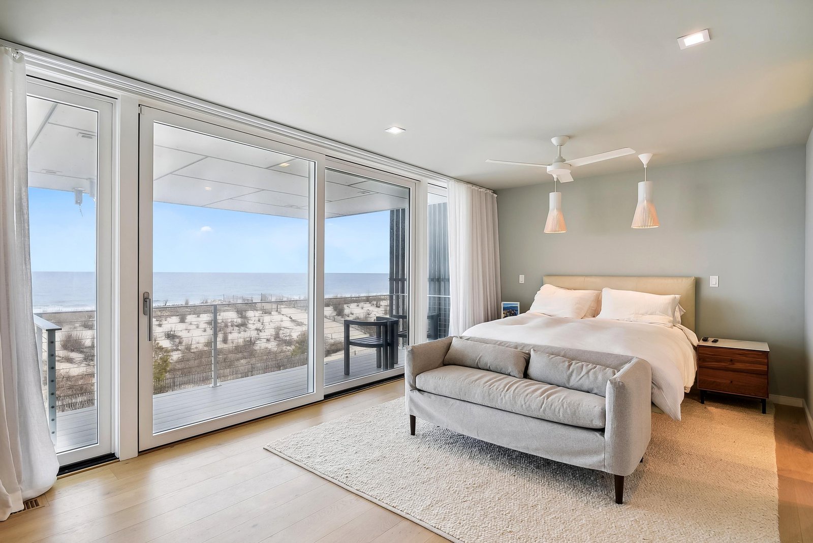 Wake up to endless ocean views through floor-to-ceiling glass doors that frame your private beachfront escape. Soft coastal tones and plush bedding invite you to unwind in this serene sanctuary by the sea.
