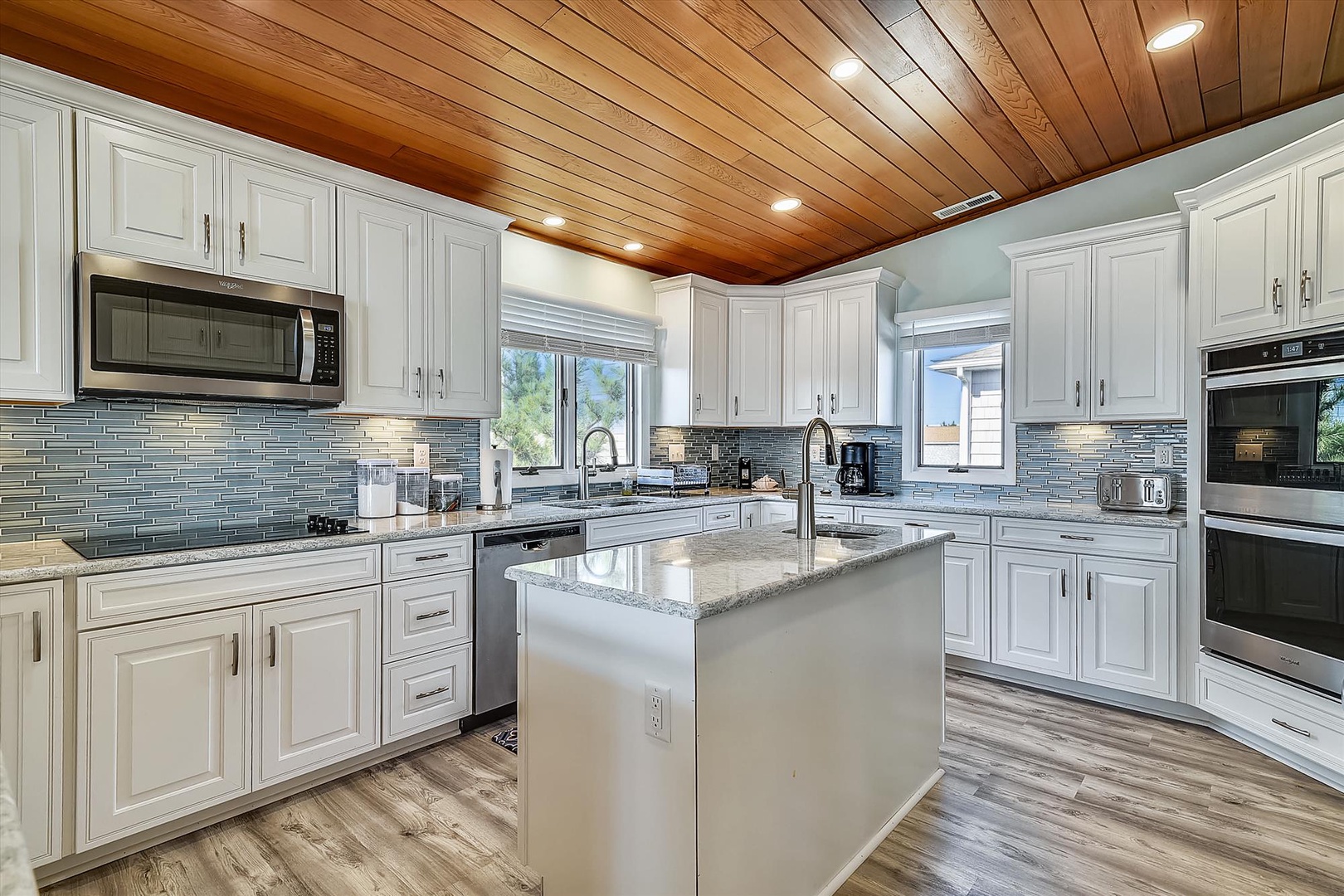Step into your gourmet kitchen, where a stunning wood plank ceiling sets the tone for memorable meals. The spacious center island and gleaming countertops invite you to gather, cook, and create together.