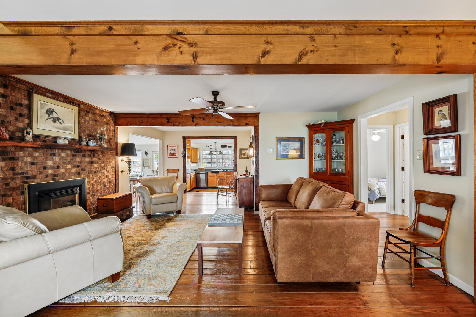 Step into your warm, inviting living room with exposed wooden beams, cozy brick fireplace, and comfortable seating—perfect for relaxing after a day of exploring.