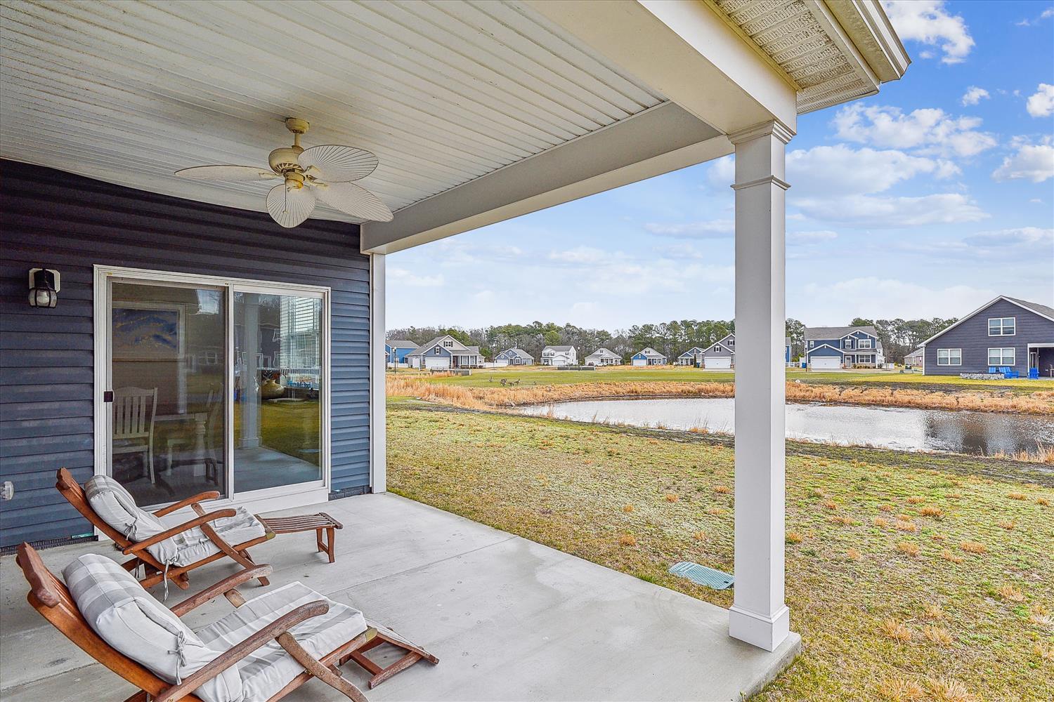 Relax on your covered patio with serene water views, where ceiling fans keep you comfortable while you unwind in cushioned lounge chairs.