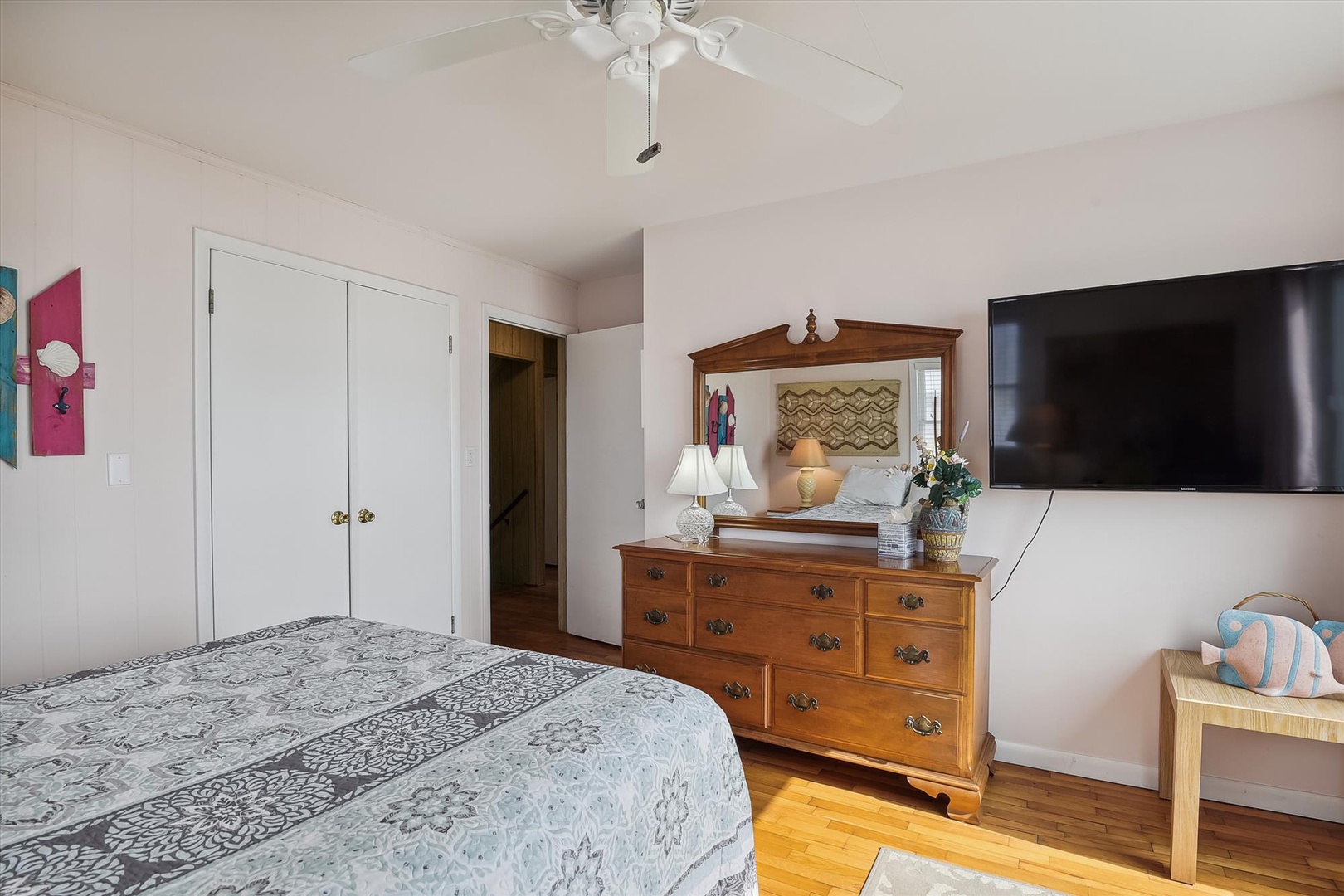 Unwind in your cozy bedroom, complete with charming wood furnishings, a ceiling fan for comfort, and a flat-screen TV for your favorite shows after a day of adventure.
