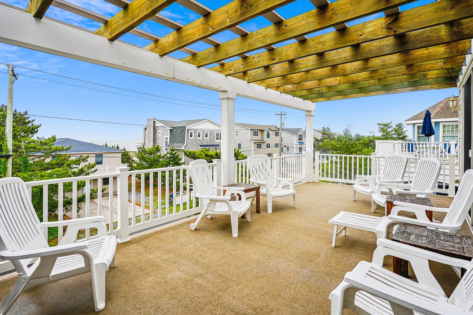 Expansive rooftop deck with pergola and lounge chairs where you can soak up sunshine while enjoying neighborhood views. Perfect for morning coffee or evening relaxation in the fresh air.