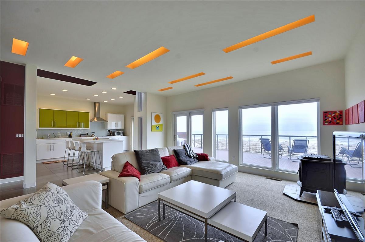 A bright open-plan living space where you can unwind with ocean views through floor-to-ceiling glass doors, modern comforts, and direct balcony access perfect for morning coffee or sunset watching.