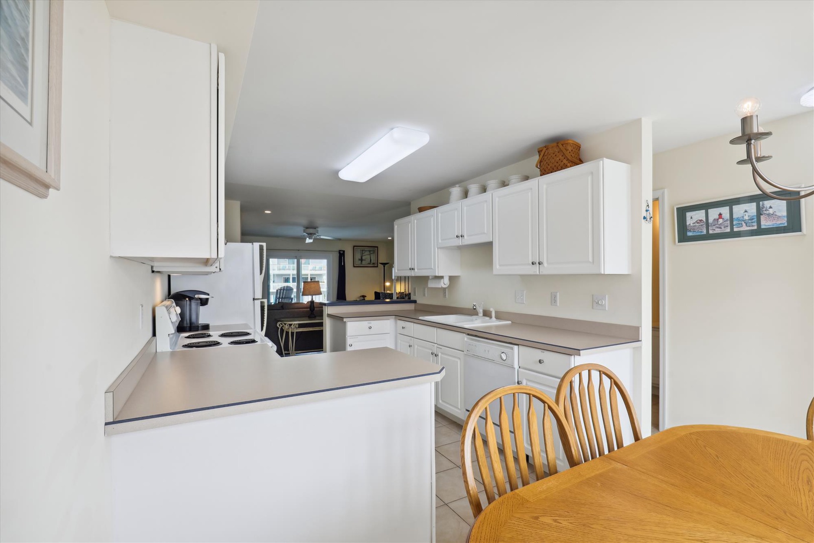 Your fully-equipped kitchen awaits with bright white cabinetry, ample counter space, and everything you need to prepare memorable meals together during your stay.