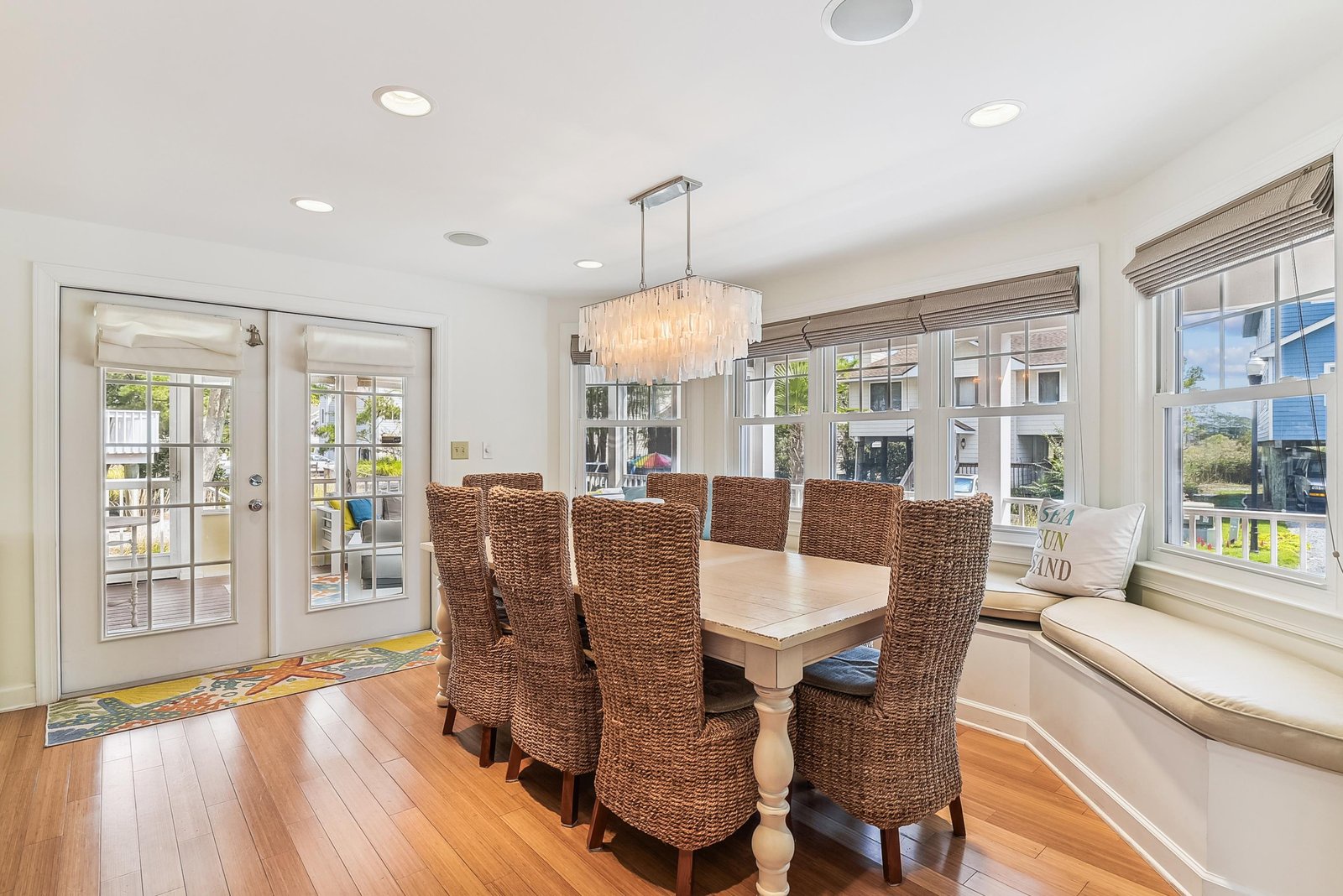Gather around this elegant dining table under a stunning chandelier. Natural light streams through expansive windows, creating a warm and inviting space where your group can share memorable meals together.