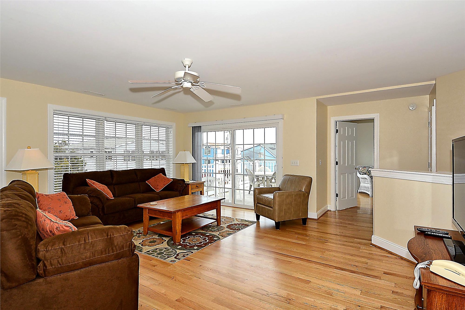 Relax in your inviting living space with warm wood floors, comfortable seating, and natural light flooding through glass doors that open to your private balcony.
