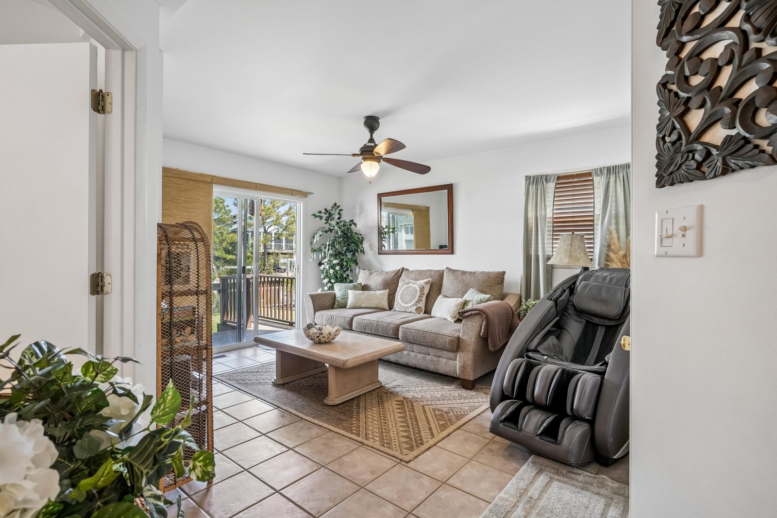 You'll love unwinding in this bright, comfortable living space, featuring a plush massage chair, airy access to your private balcony, and cozy seating perfect for relaxation after a day of exploring.