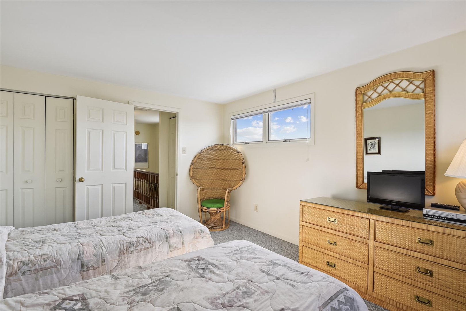 Your comfortable bedroom features twin beds with charming rattan furnishings and natural light streaming through the windows, offering a peaceful retreat after a day of adventure.