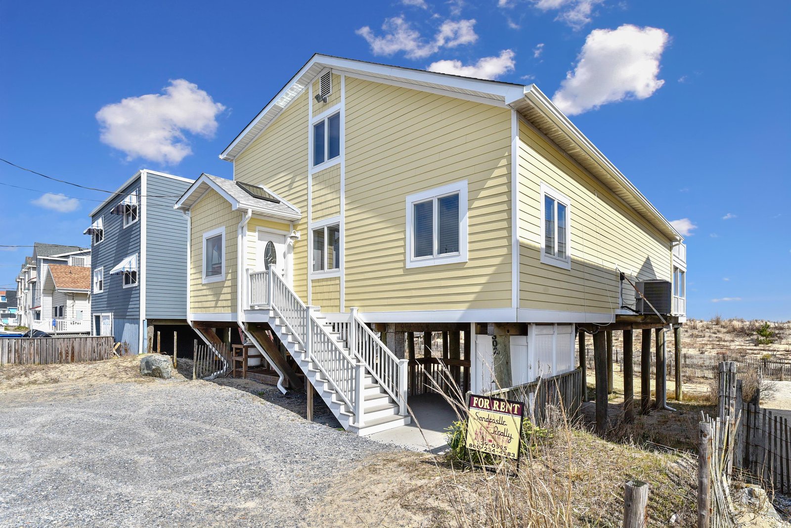 This charming beachside home sits elevated just steps from the sand, offering direct coastal access and classic beach house style. Bright yellow siding and a private entrance welcome you to your seaside escape.