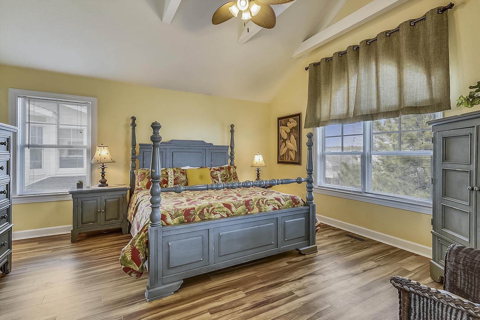 Unwind in your charming bedroom featuring a stately four-poster bed, warm yellow walls, and peaceful window views that invite restful nights.