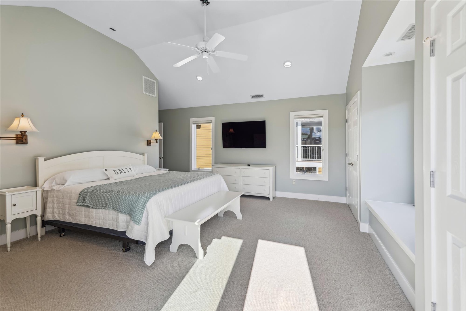 Drift off under soaring vaulted ceilings and soft coastal breezes. Your spacious bedroom features a plush king bed, calming coastal décor, and a flat-screen TV for cozy evenings in.
