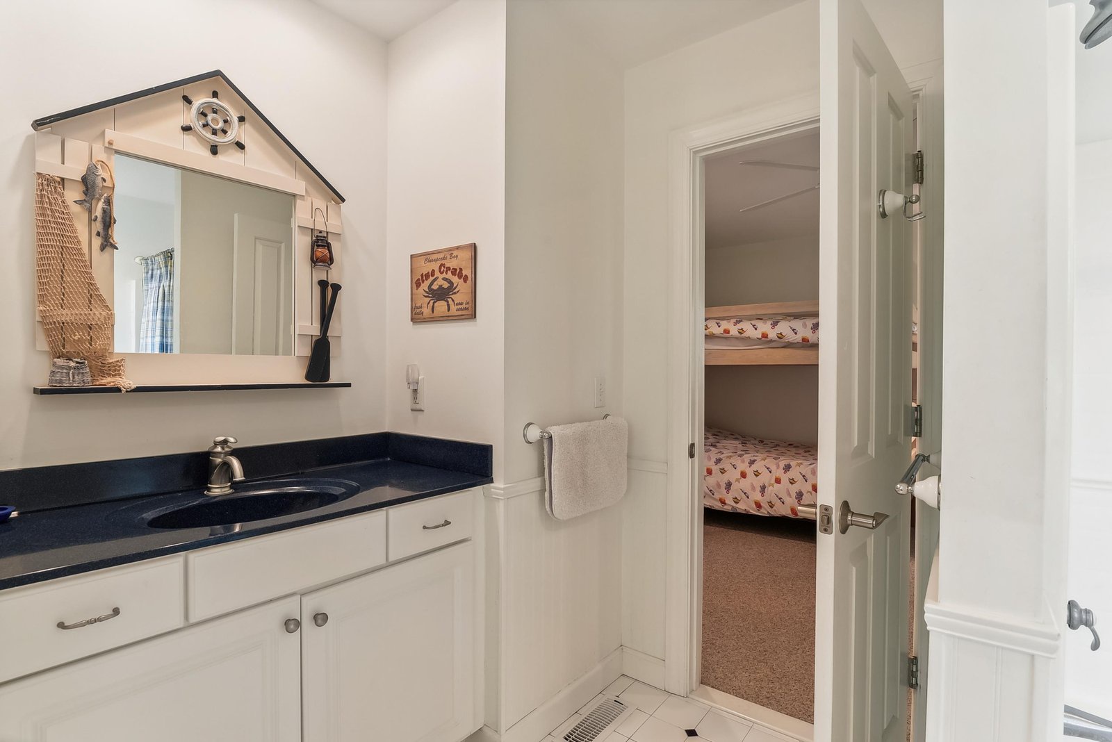 Charming nautical-themed vanity with coastal decor touches adds character to your fresh, bright bathroom space.