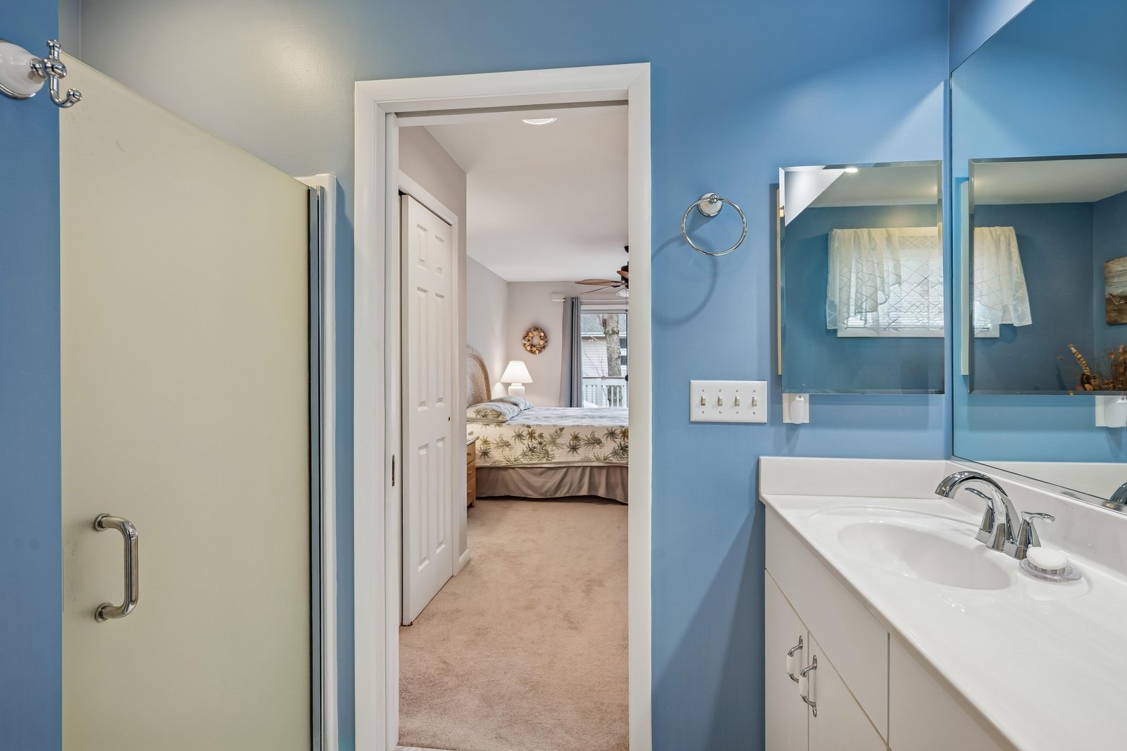This serene blue bathroom offers fresh towels and a peaceful view into your cozy bedroom, creating a private sanctuary where you can unwind after exploring the area.