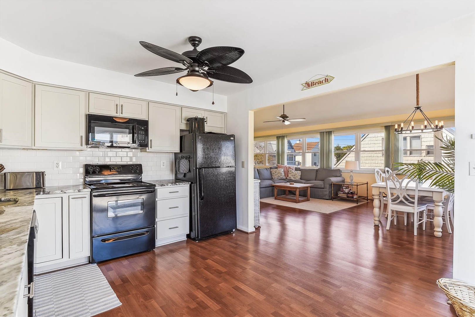 Step into your bright beachside retreat, where gleaming hardwood floors flow from the fully-equipped kitchen into your open living and dining space—perfect for gathering after sun-soaked days.