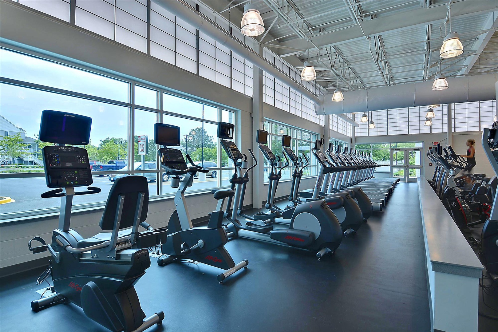 You'll love working out in this spacious fitness center with floor-to-ceiling windows flooding natural light across modern cardio equipment.