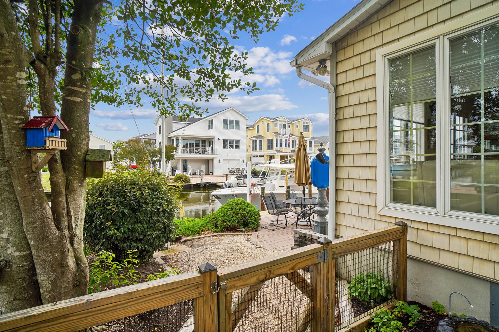 Your backyard opens to peaceful waterfront views, where your private patio invites quiet mornings by the canal with boats gently drifting by and a lush garden framing the scene.