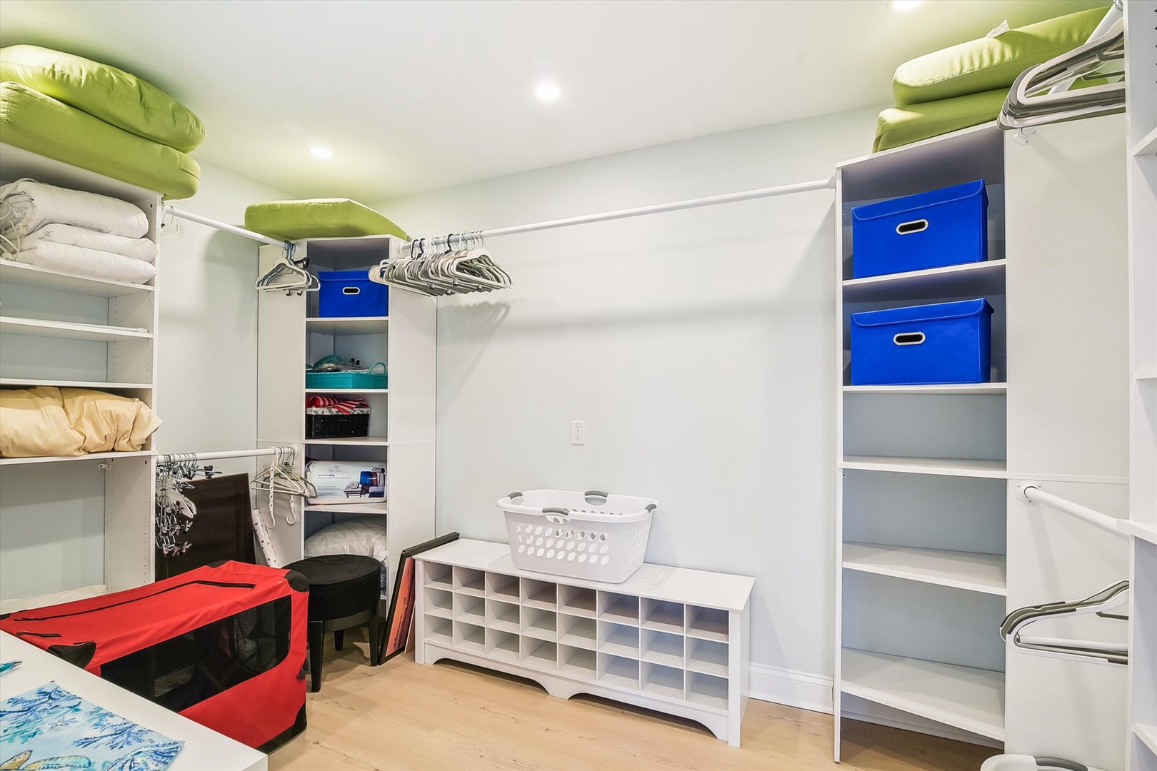 Your organized walk-in closet offers abundant storage with shelving, hanging space, and colorful bins to keep your belongings perfectly arranged.