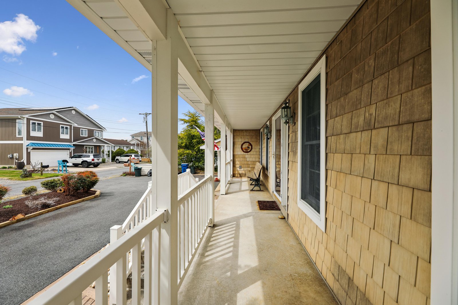 A bright front porch welcomes you home, with neighborhood views and plenty of space to greet the day. The clean lines and natural shingles create a warm, beachside feel.