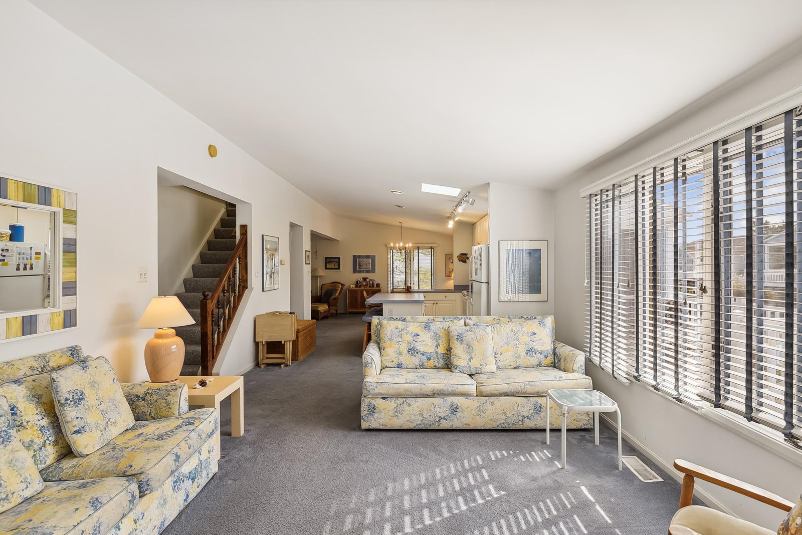 Settle into your bright, airy living space where soft natural light filters through elegant blinds and cozy floral sofas invite you to unwind after a day of adventure.