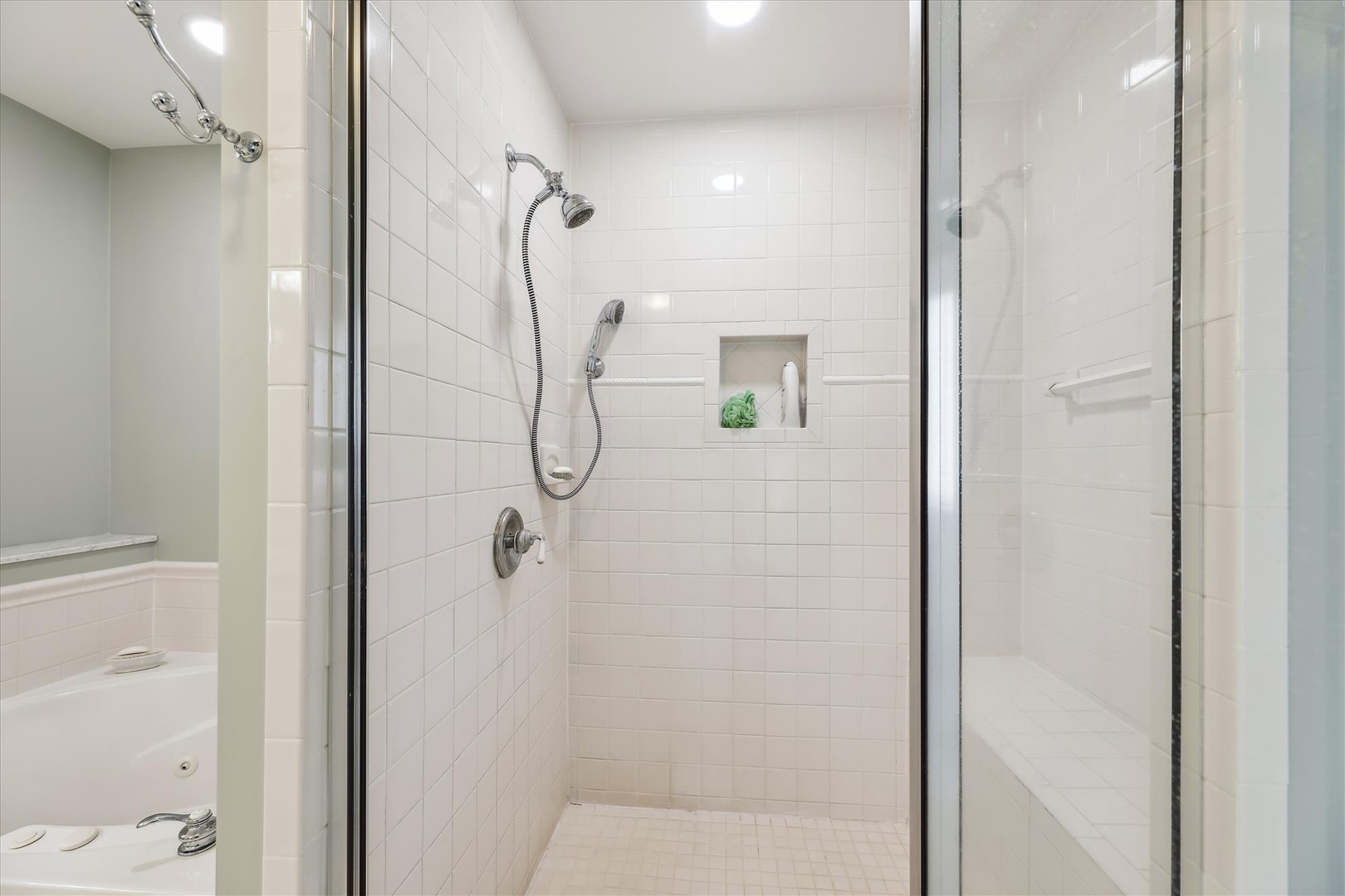 Step into your private walk-in shower with dual showerheads and spotless white tile. A built-in niche keeps your essentials within easy reach for a refreshing, hassle-free start to your day.