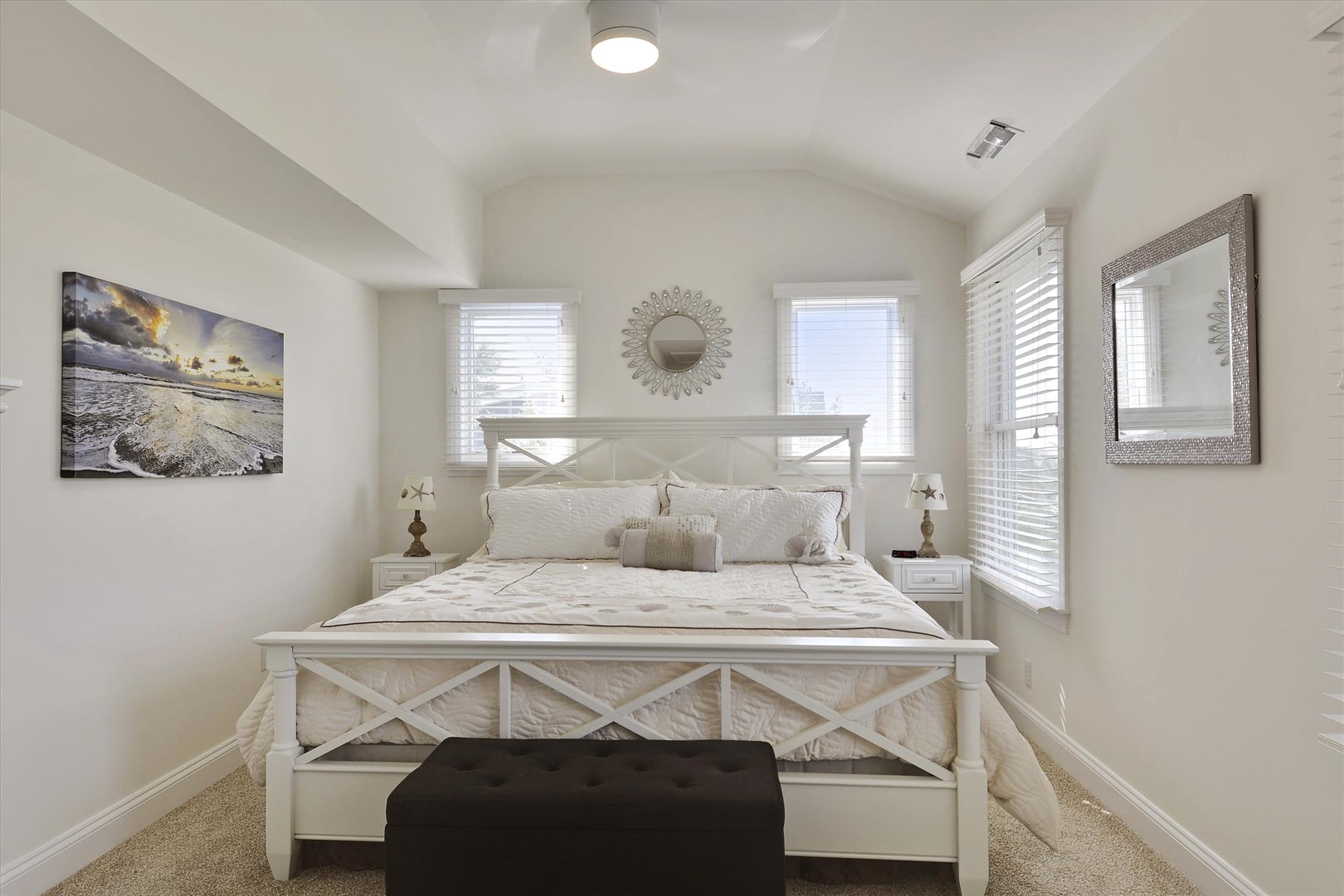 Sink into the plush coastal-inspired bedding and let the natural light streaming through double windows set a peaceful tone for your mornings and evenings here.