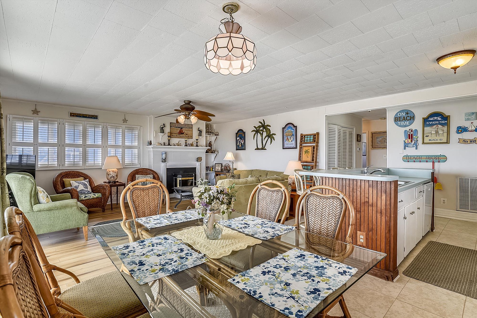 Bright, coastal living and dining area with beachy décor, ceiling fans, and a full kitchen just steps away—your perfect home base for relaxed island living.