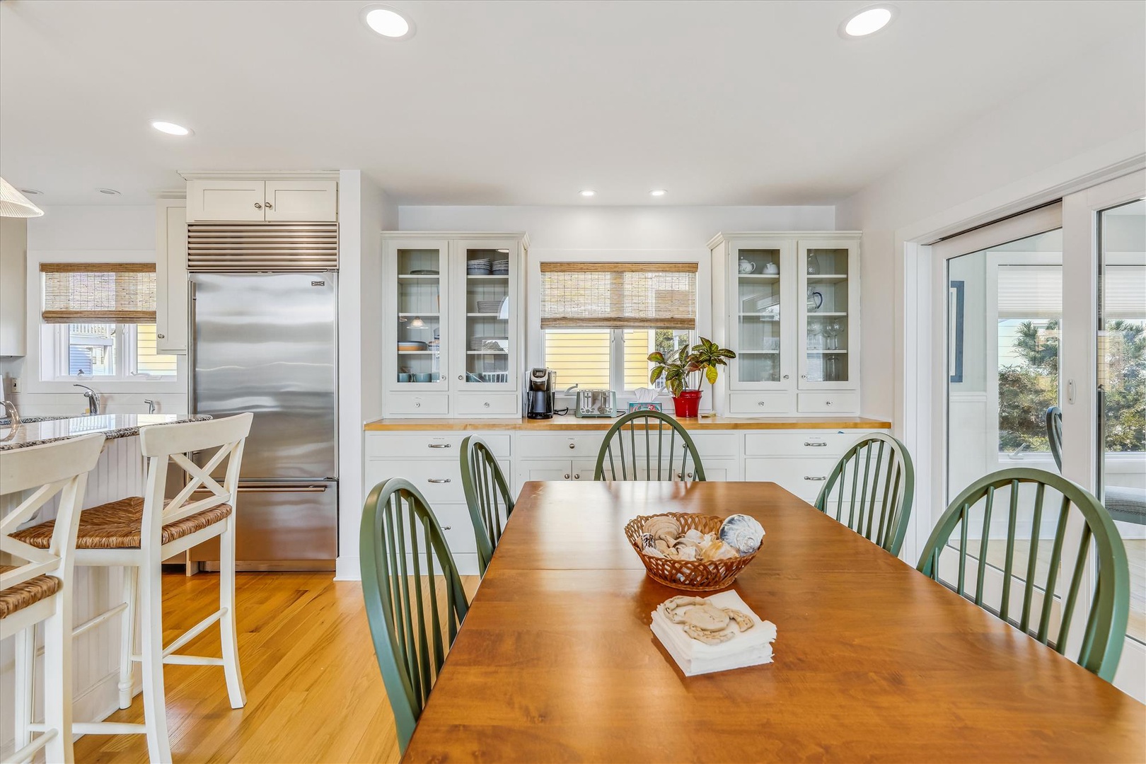 Picture yourself gathering here with loved ones for morning coffee or evening meals. Bright, welcoming space with gleaming counters, modern appliances, and a charming coastal vibe that invites you to settle in and feel at home.