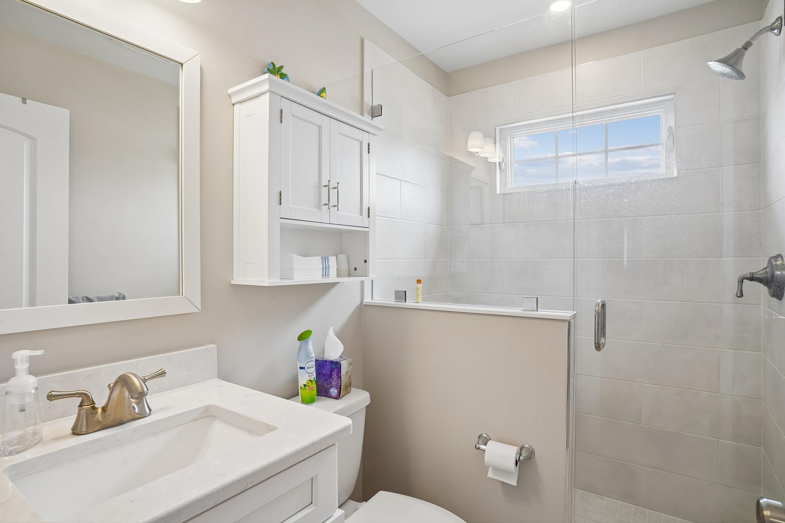 Step into your private, freshly updated bathroom with crisp white tiling, a spacious walk-in shower, and plenty of natural light to start your day feeling refreshed.