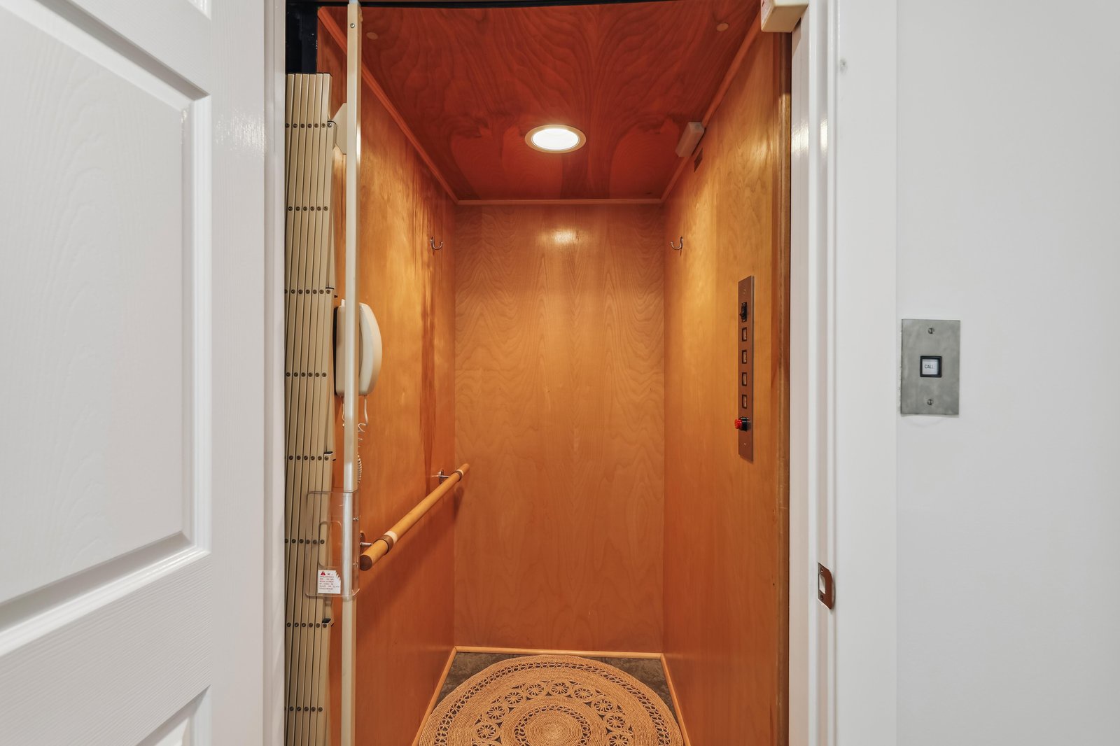 Your private elevator awaits, offering direct access to your retreat with warm wood finishes and thoughtful lighting to welcome you home.