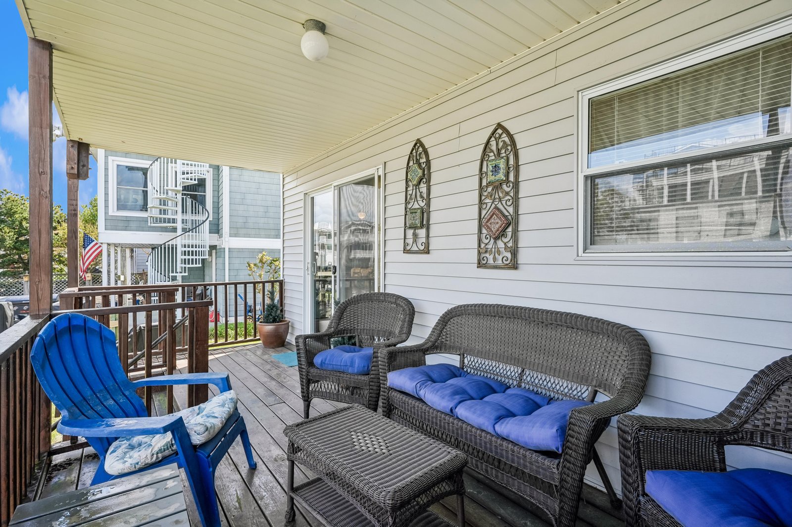 Relax on your private covered porch with cozy wicker seating and refreshing blue cushions. Sip your morning coffee while enjoying the peaceful neighborhood views—your ideal spot to unwind after exploring the area.