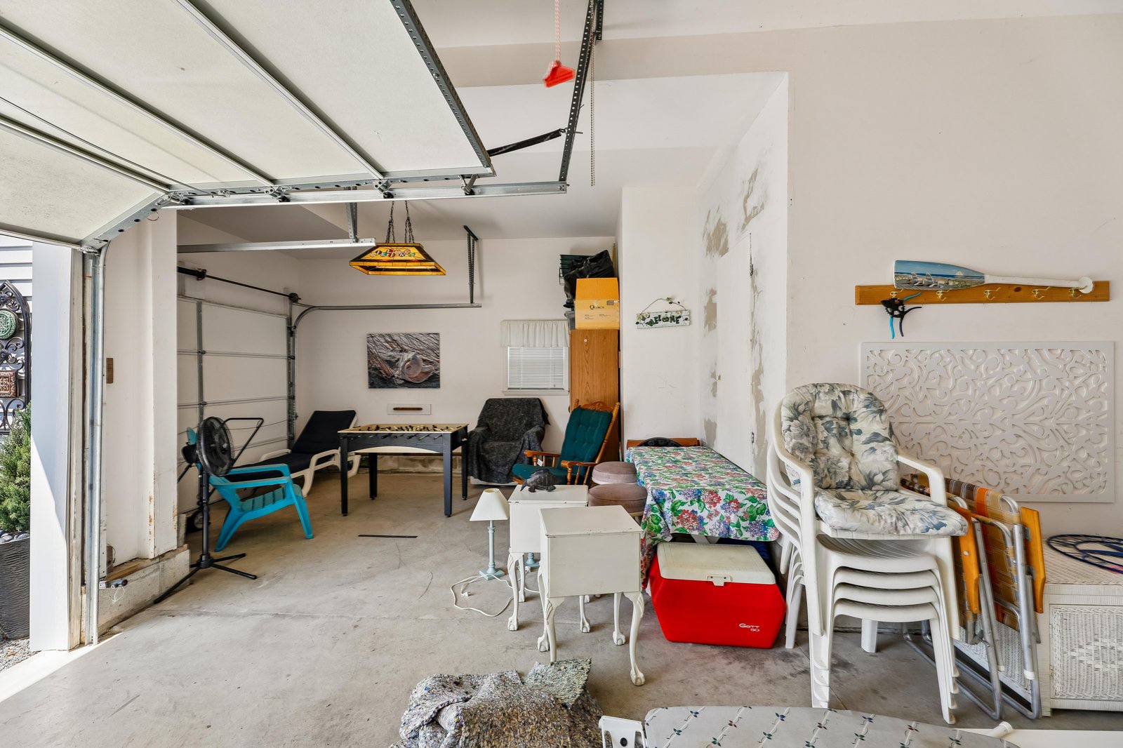 Unique multi-purpose space with a creative indoor-outdoor vibe, featuring a pool table, colorful seating, and garage-style opening for flexible entertaining possibilities.