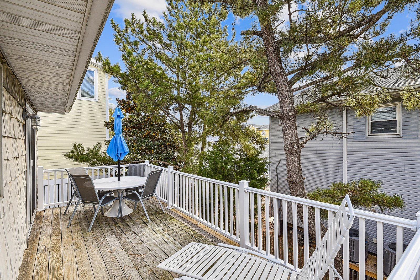 This sunny outdoor deck offers a perfect spot to relax and enjoy your morning coffee or evening sunset. Surrounded by mature trees and tucked between neighboring homes, this space invites you to unwind in your own private retreat.