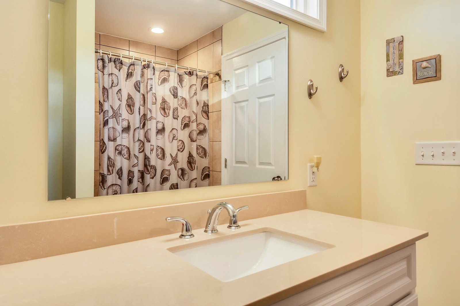 Your bright bathroom features a spacious vanity and charming coastal details, with a tiled shower waiting to refresh you after sunny beach days.