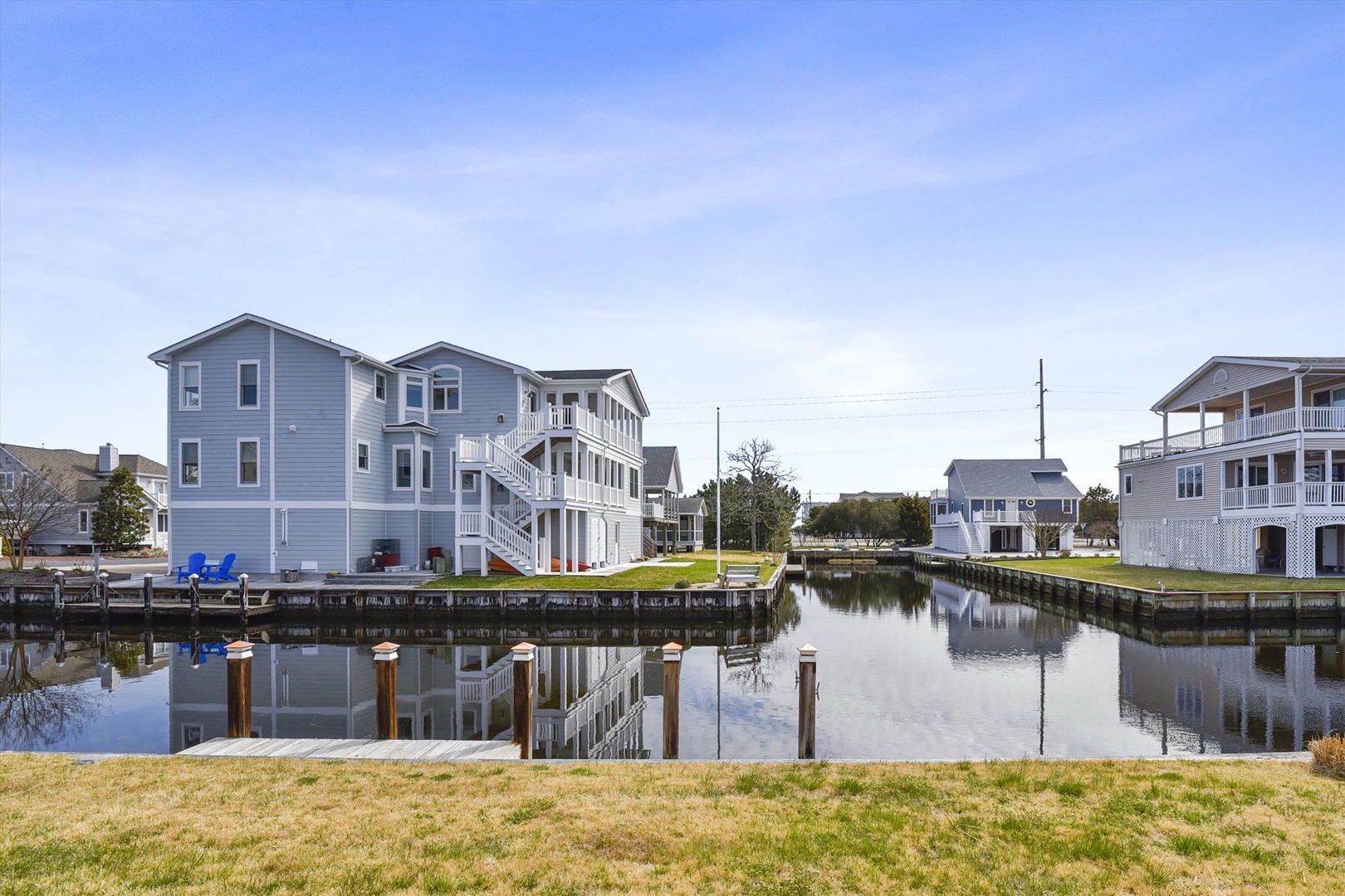 Waterfront vacation homes with private docks on a peaceful canal, offering tranquil views in a serene coastal neighborhood perfect for a getaway.
