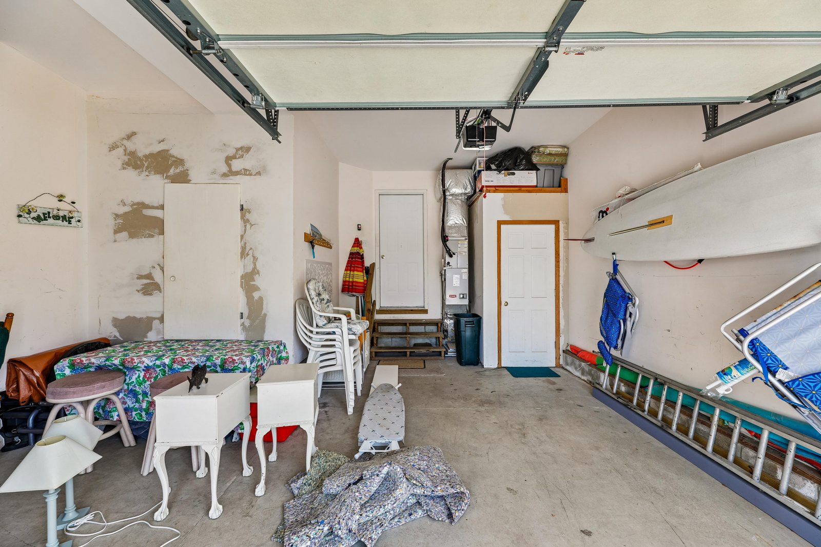 Storage garage with shelving, seating, and garage door opener. Not a guest living space—utility area for property equipment and storage needs.