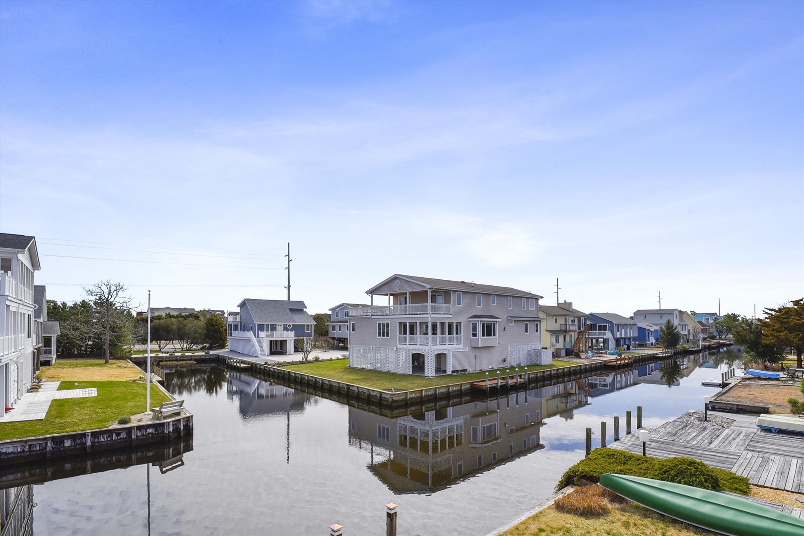 Waterfront vacation homes line a tranquil canal, offering peaceful access to boating and waterside relaxation in a coastal neighborhood.
