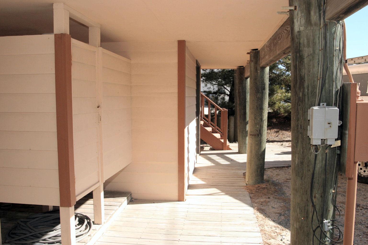 The covered entrance walkway leads to your private retreat, with rustic wooden posts and natural desert surroundings creating a peaceful arrival experience.