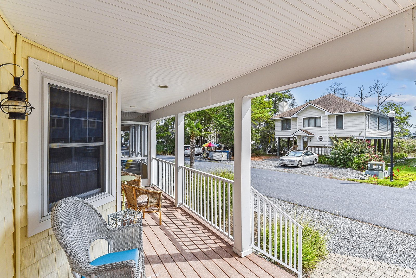 A welcoming front porch with comfortable seating overlooks the quiet residential street and neighboring homes, providing a peaceful spot to start your day.