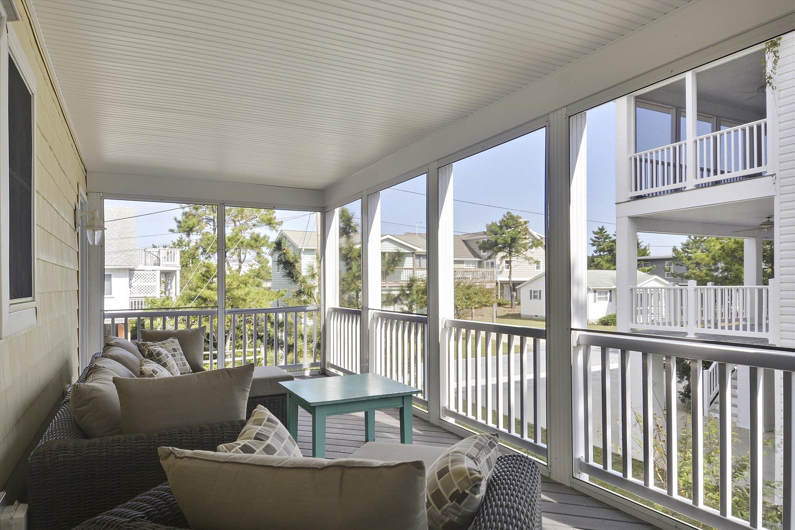 Your private screened porch with cozy seating invites you to unwind and enjoy the coastal breeze while taking in peaceful neighborhood views.