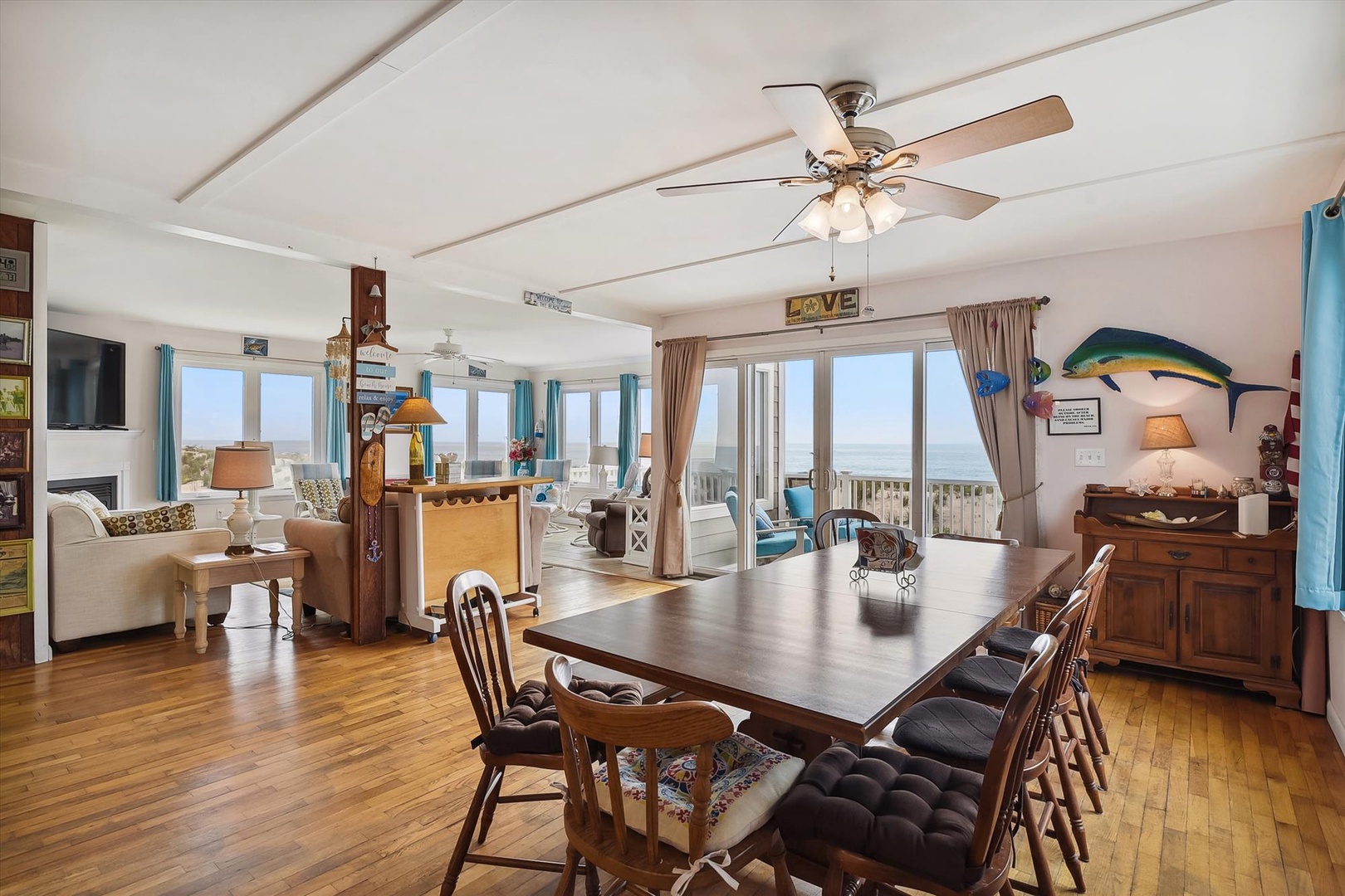 This bright open-concept living space features ocean views, comfortable seating, and a dining table for eight—perfect for your beach getaway meals.