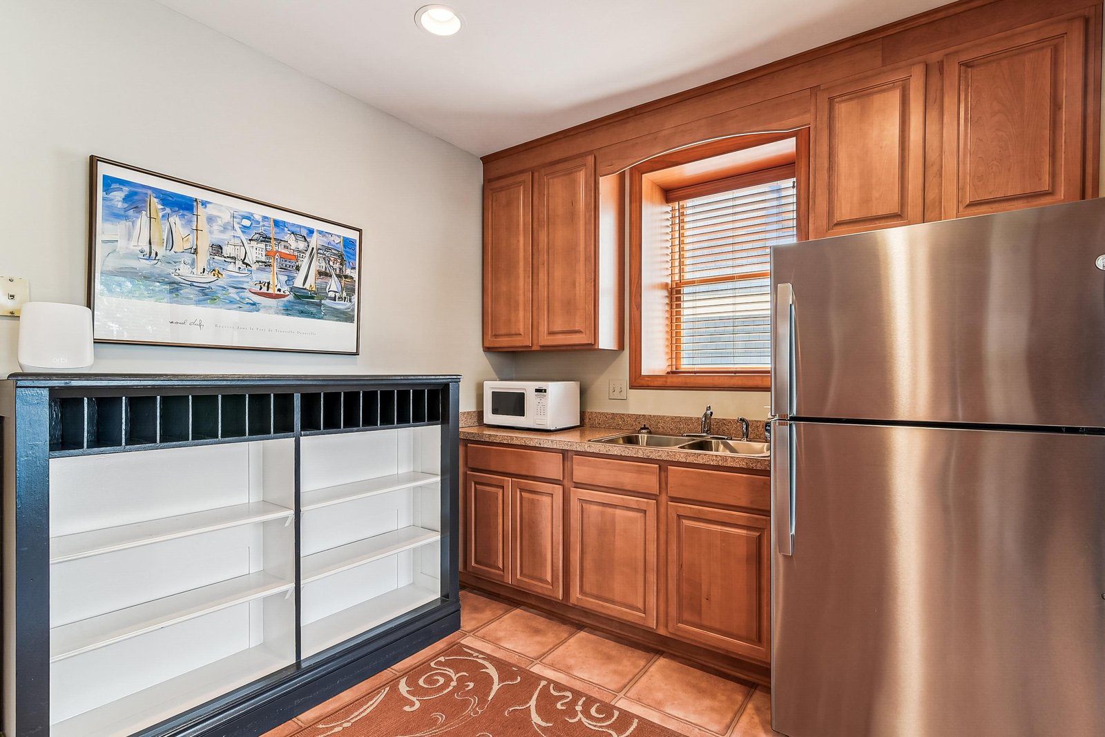 Your fully equipped kitchen features warm wood cabinetry, granite countertops, stainless steel appliances, and a bright window that fills the space with natural light.