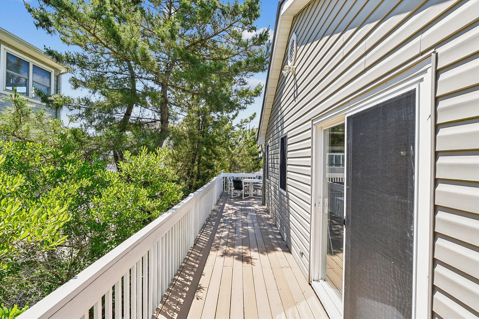 Spacious deck surrounded by mature trees offers a private outdoor retreat where you can enjoy morning coffee or evening sunsets in peaceful natural surroundings.