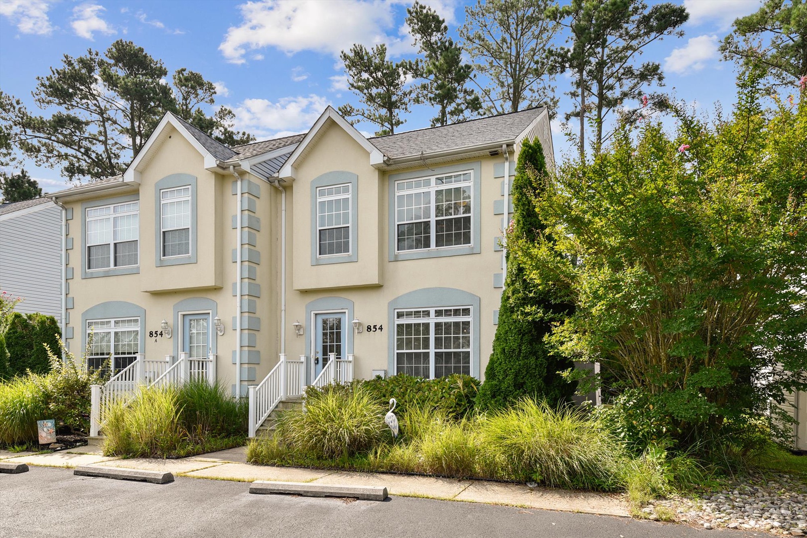 A charming townhome with fresh coastal styling, nestled among mature pines and lush landscaping. Property #854 features spacious rooms and bright natural light throughout, surrounded by a serene neighborhood setting.