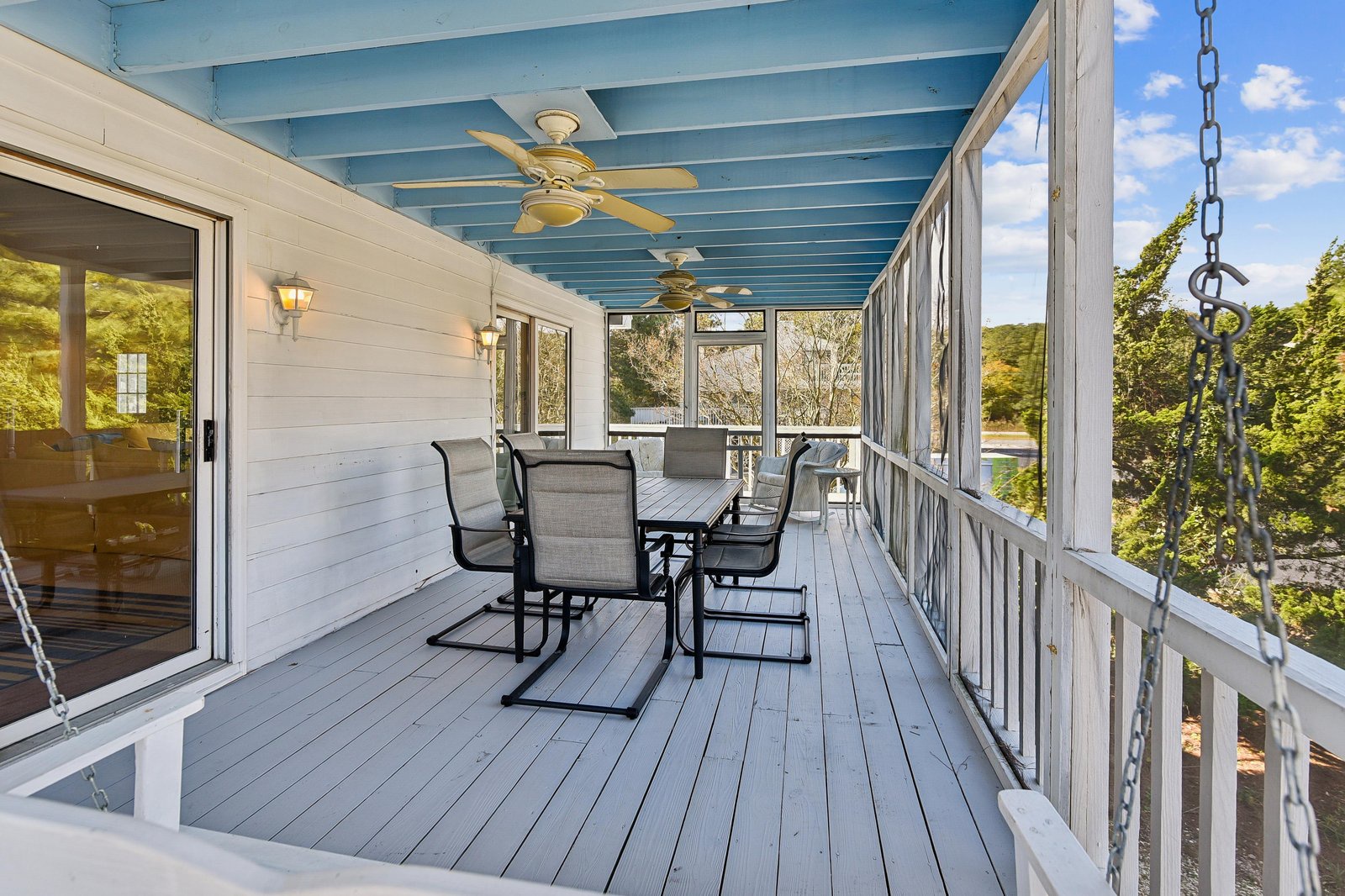 Picture yourself sipping morning coffee on your private screened porch, where ceiling fans keep you cool as you gaze out at lush trees and natural surroundings—perfect for peaceful meals or unwinding after a day of adventure.
