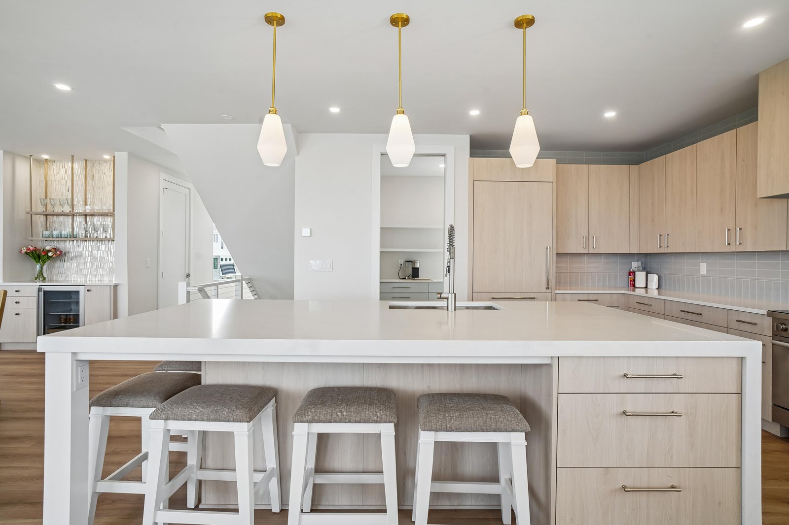 Your bright, airy kitchen awaits with warm wood cabinetry, sleek quartz countertops, and pendant lighting that sets a welcoming glow for cooking and gathering with loved ones.