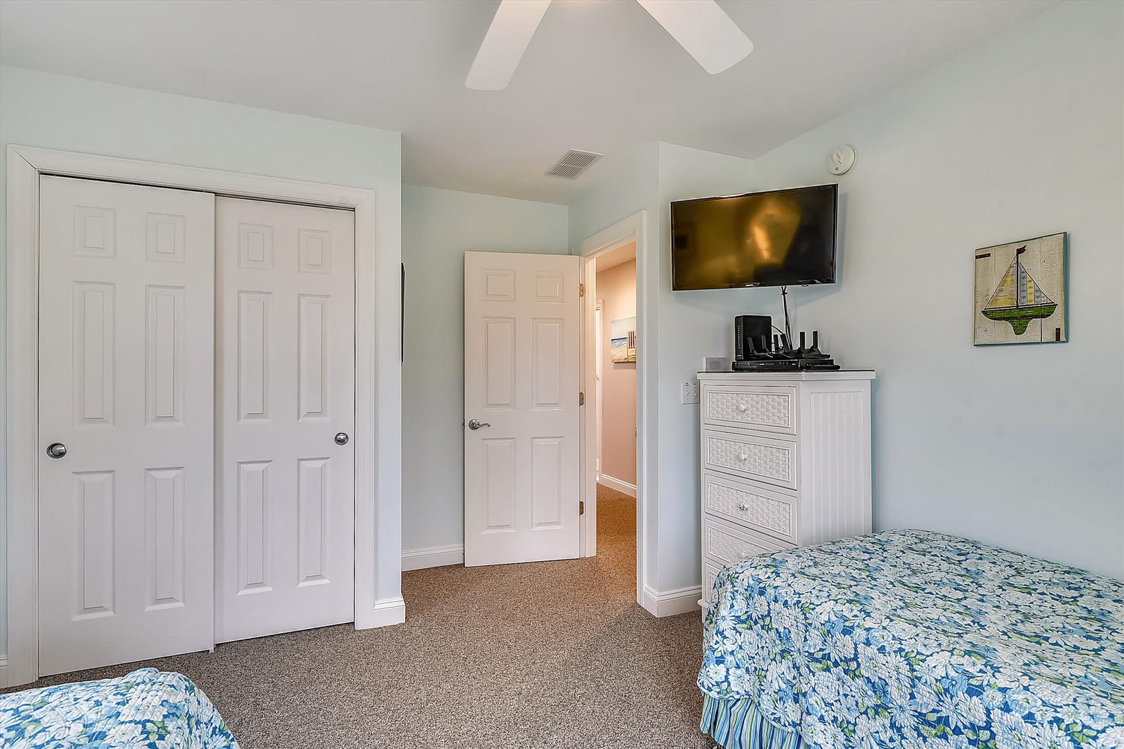 Unwind in your bright, beach-inspired bedroom with ceiling fan, smart TV, and cheerful nautical decor—your serene coastal retreat awaits.