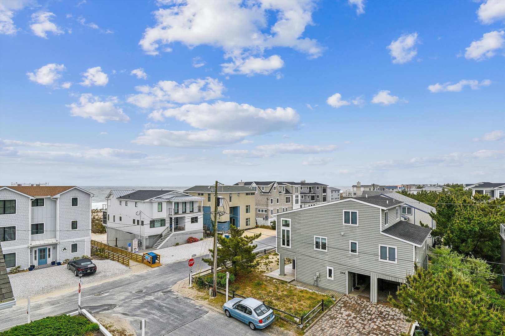 Elevated view of a peaceful beach community with a mix of coastal homes, quiet streets, and glimpses of the ocean on the horizon.