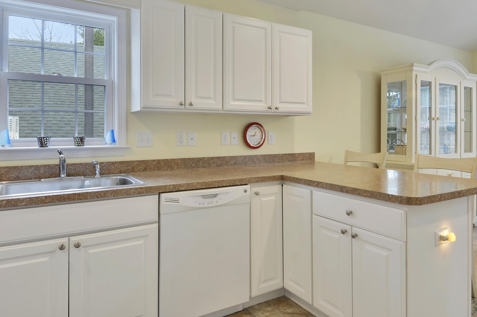 Your fully equipped kitchen features clean lines, warm countertops, and plenty of cabinet space. Natural light pours in through the window, making meal prep feel bright and welcoming.