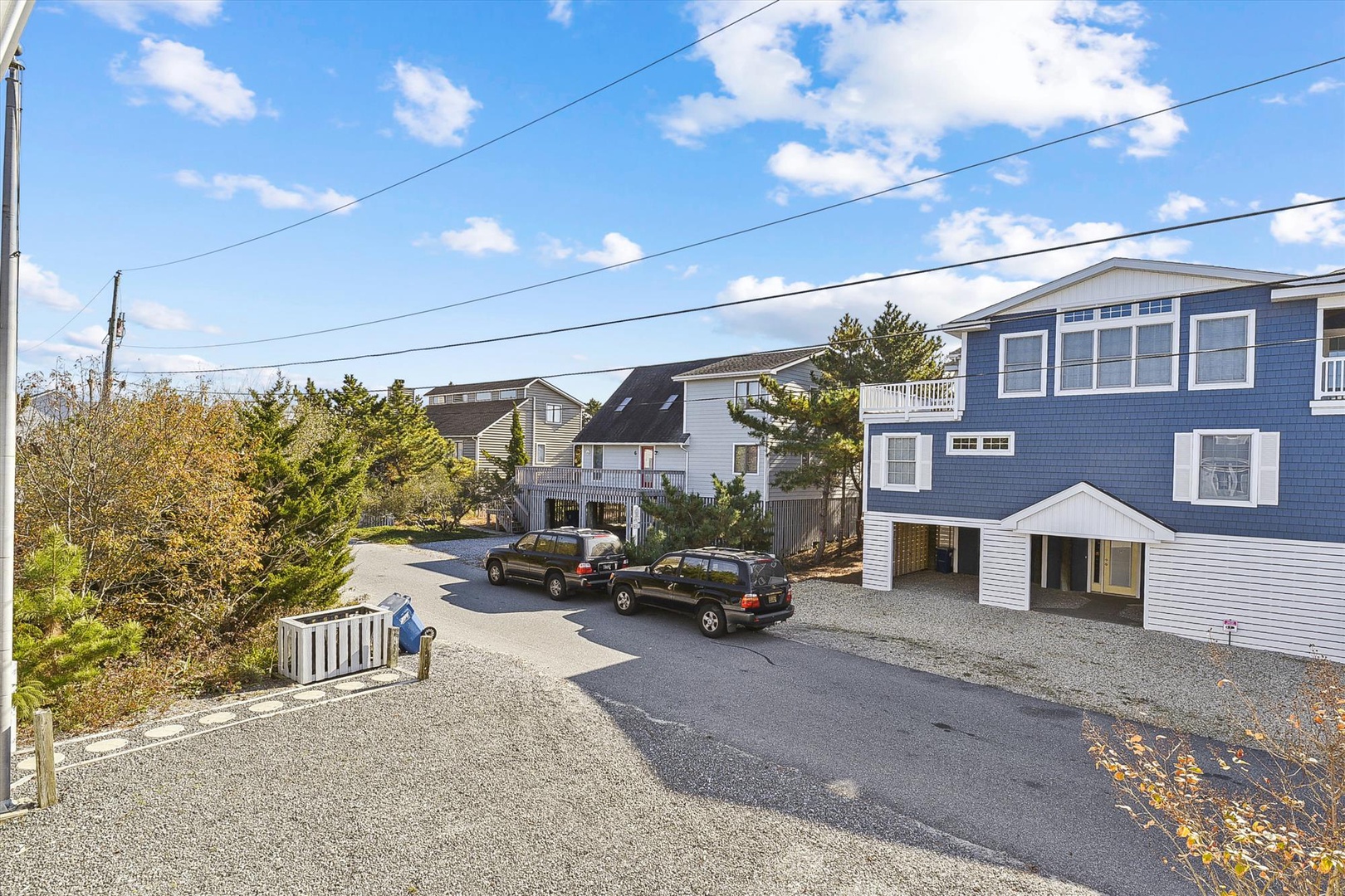 Charming coastal property featuring blue and white siding, nestled in a quiet residential neighborhood with convenient parking and easy beach access just steps away.