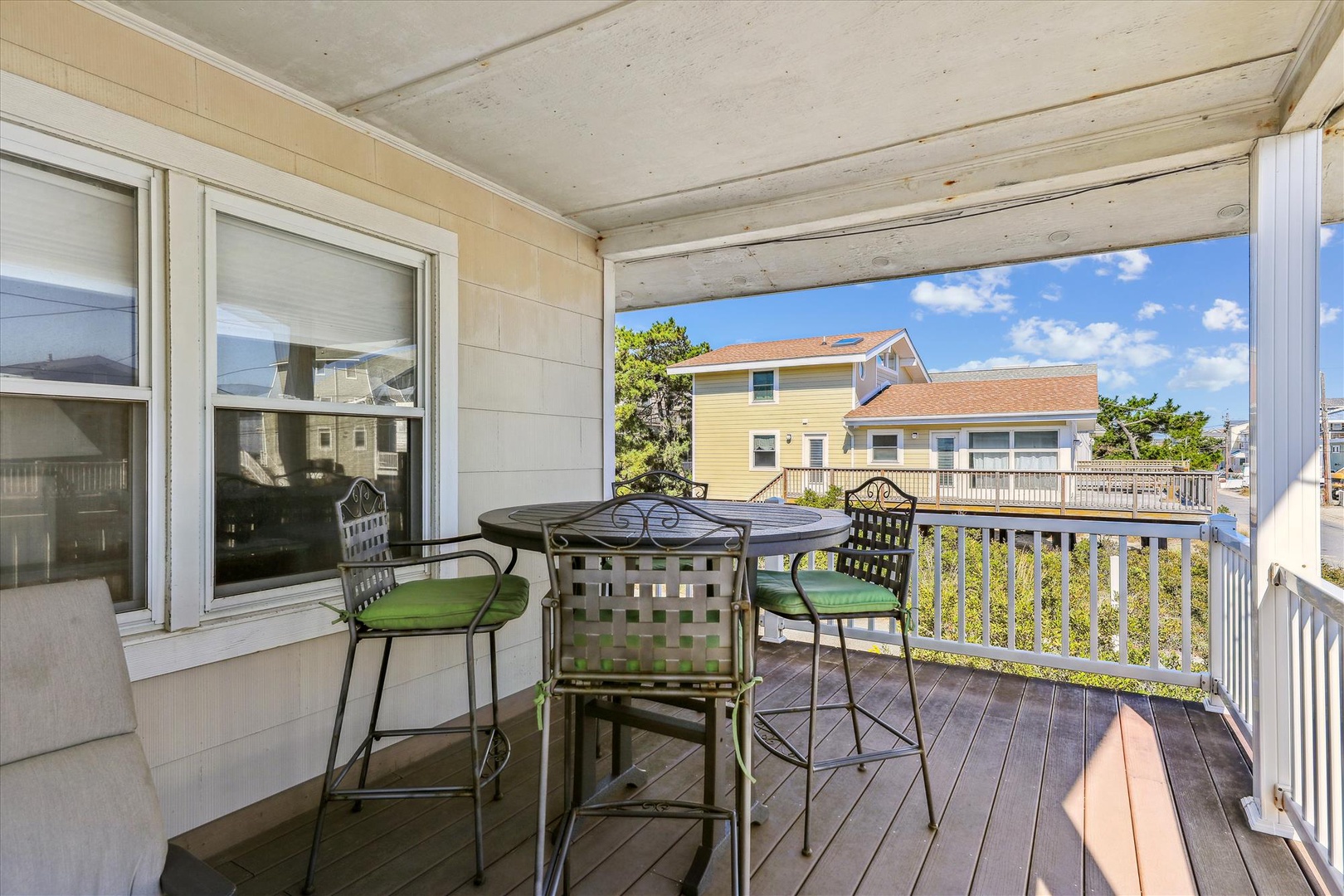 Sip your morning coffee at this charming bistro table on your private covered balcony, where soft coastal breezes and neighborhood views create the perfect start to your beach day.